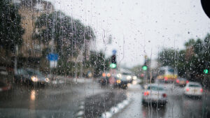 Blurred street scene through car windows with rain drop