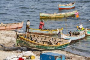 Unidentified poor local Traditional fisherman are fishing on the beach with very small colored wood boats.