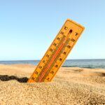 Selective focus shot of a thermometer in the beach sand with a blurred background